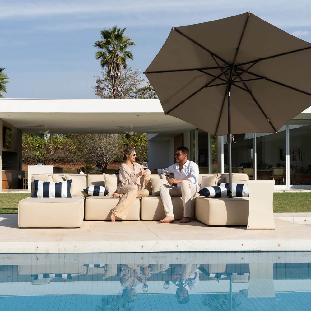 Ilustrando uma decoração de Réveillon na piscina, foto de um casal desfrutando de conforto em área externa com piscina, ombrelone e decoração moderna para festas de Ano Novo.