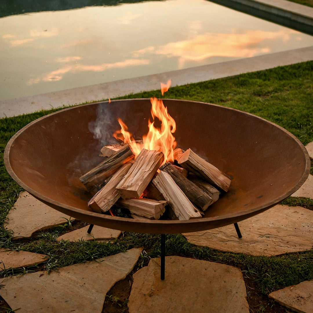 Uma lareira de tacho em um jardim externo, proporcionando calor e um ambiente aconchegante na decoração para jardim externo.